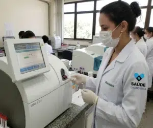 Biomedica passando uma gasometria no equipamento em laboratorio.