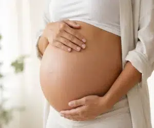 Barriga de gestante durante a gravidez em conteúdo sobre exame de toxoplasmose, sorologia usada no pré-natal para avaliar infecção por Toxoplasma gondii.